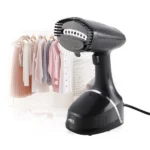 A woman using the Anex Handy Garments Steamer AG-1018 on a shirt hanging on a rack, demonstrating its effectiveness in removing wrinkles.